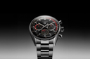 Luxury men's chronograph watch with black dial, red accents, and stainless steel bracelet